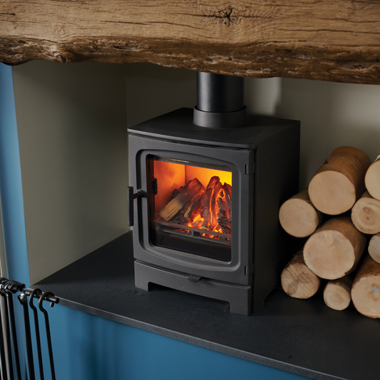 Electric stove inset with wooden logs to the side of it